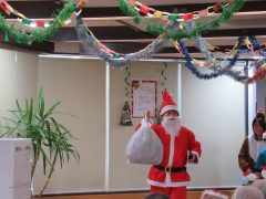 施設内のクリスマスイベント。サンタクロース衣装の人物と装飾が見られます。